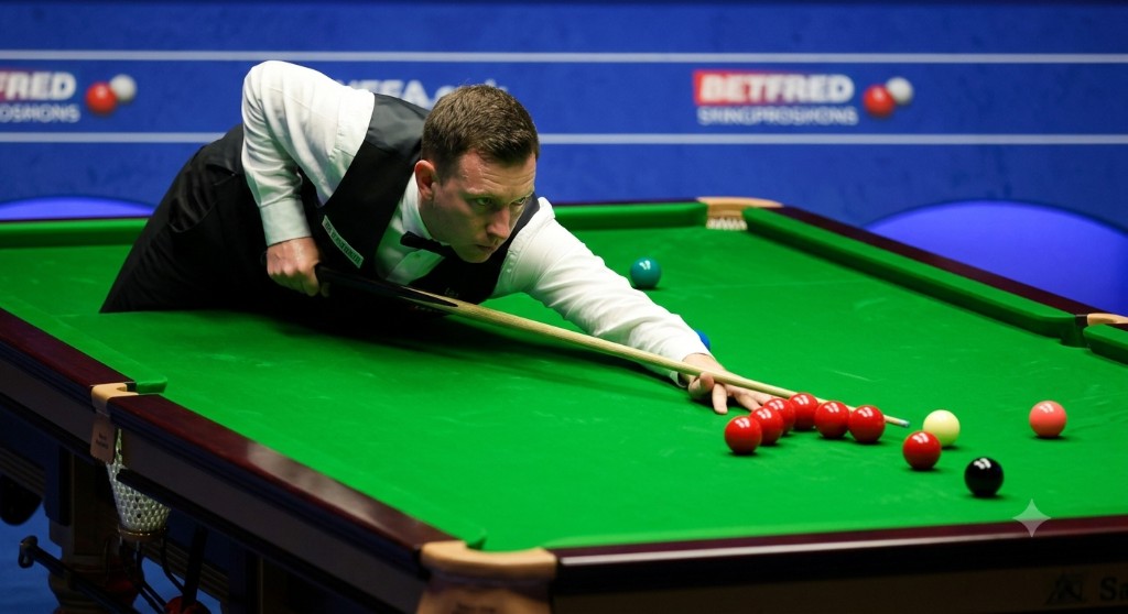 Male snooker player bending down and focusing on the red ball on a green table.